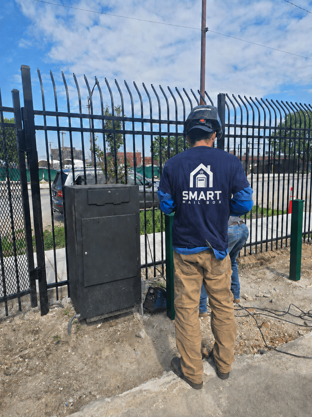 Smart Mailbox installation team fitting the delivery box to a property gate